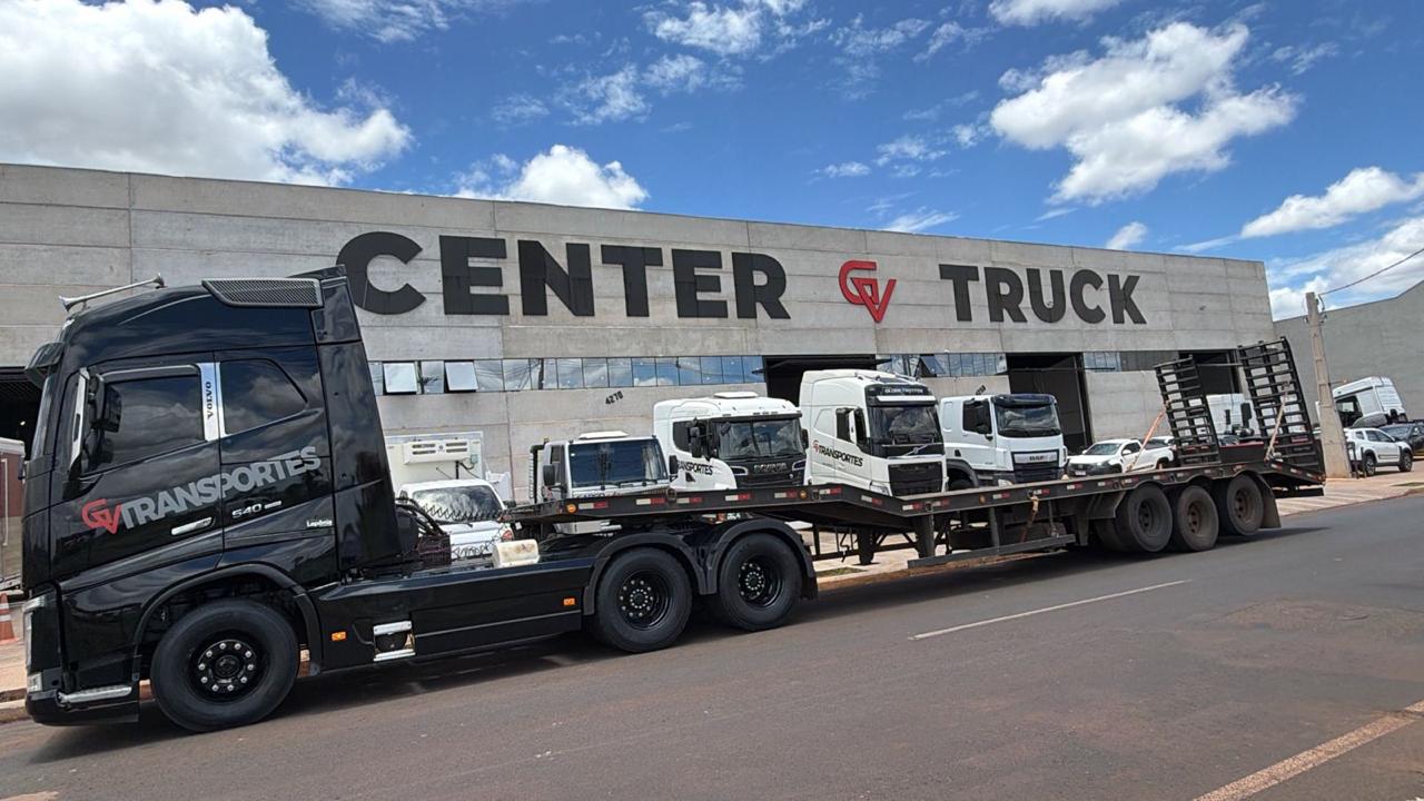 Volvo FH preto da GV Transportes com prancha em frente à Center Truck