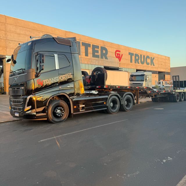 Volvo FH preto da GV Transportes transportando cavalo mecânico e trator