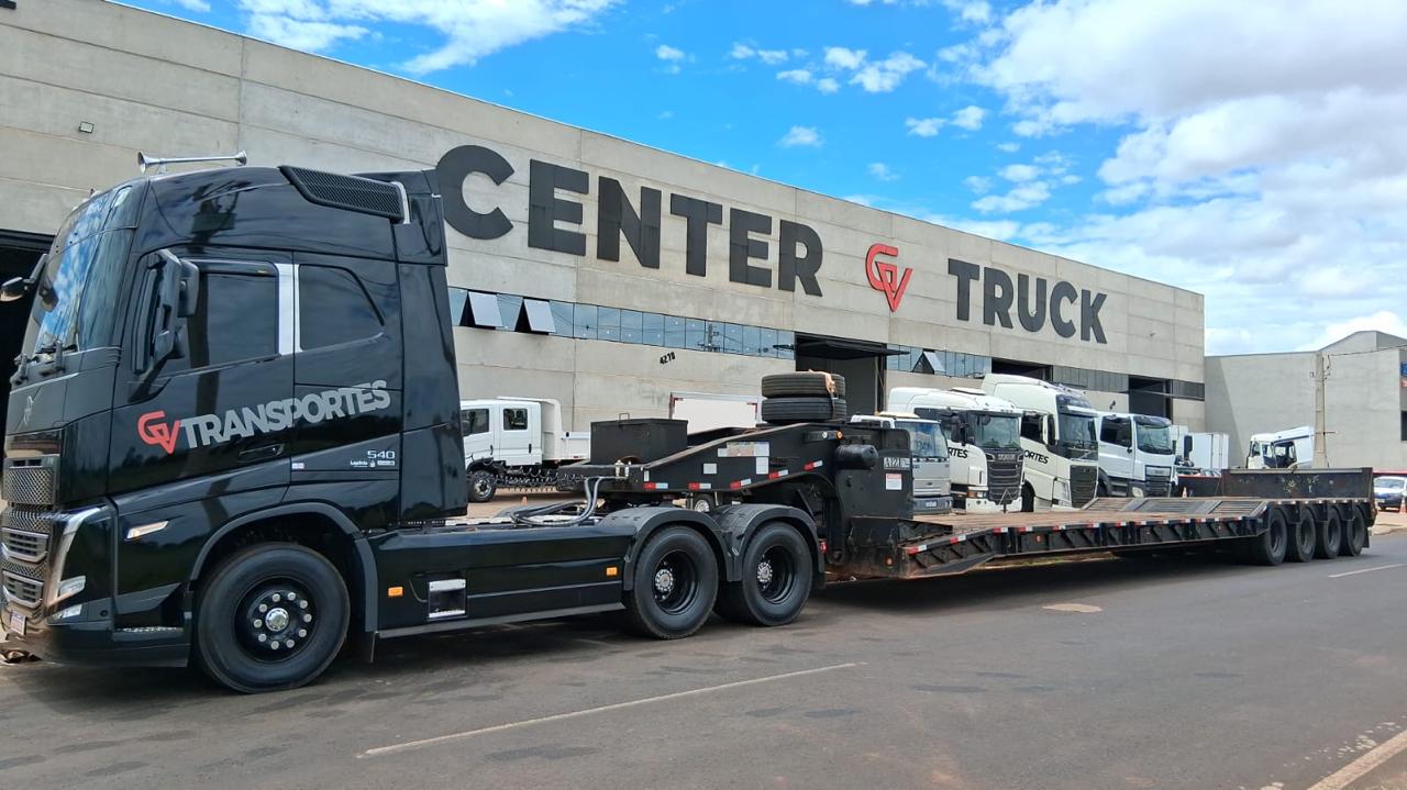 Mercedes preto da GV Transportes com prancha vermelha em frente à Center Truck